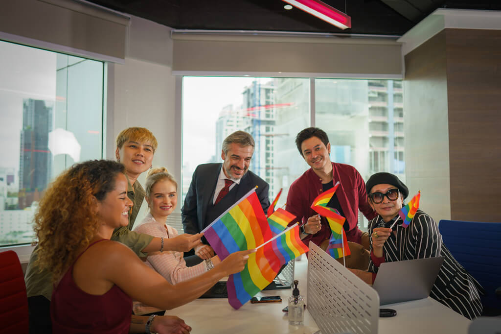 Office setting with people waving Pride flags