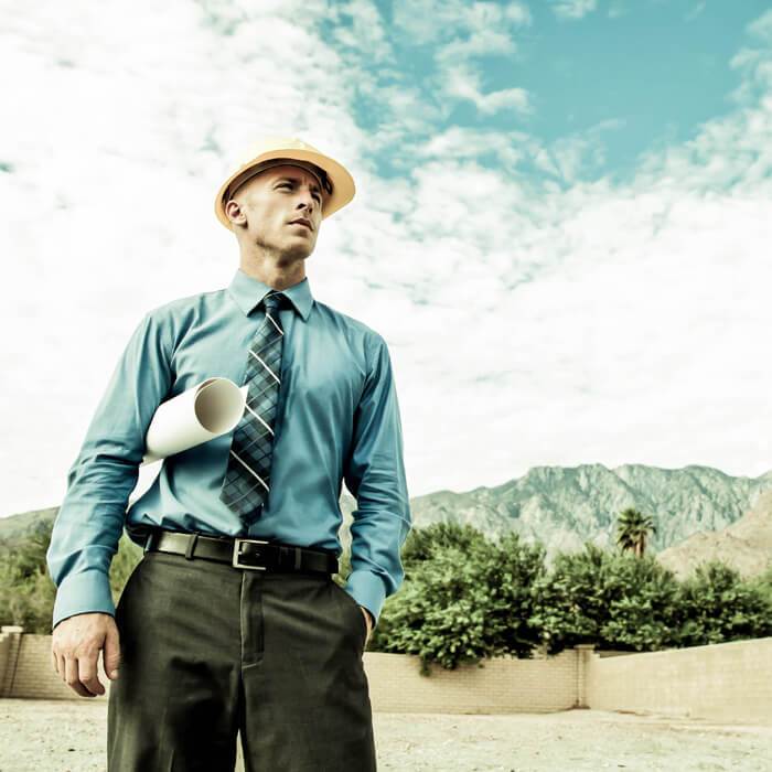 A businessman wearing a hard hat at a construction site